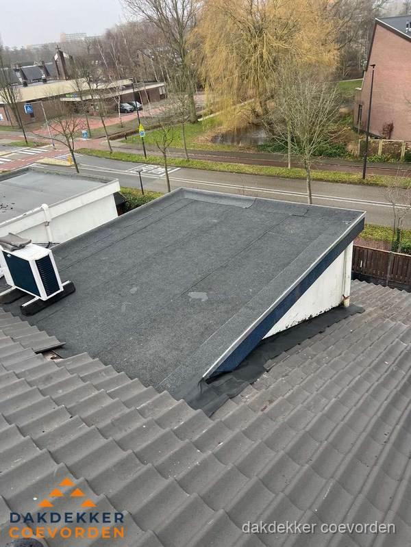 Plat dak met bitumen dakbedekking naast schuin pannendak in Coevorden