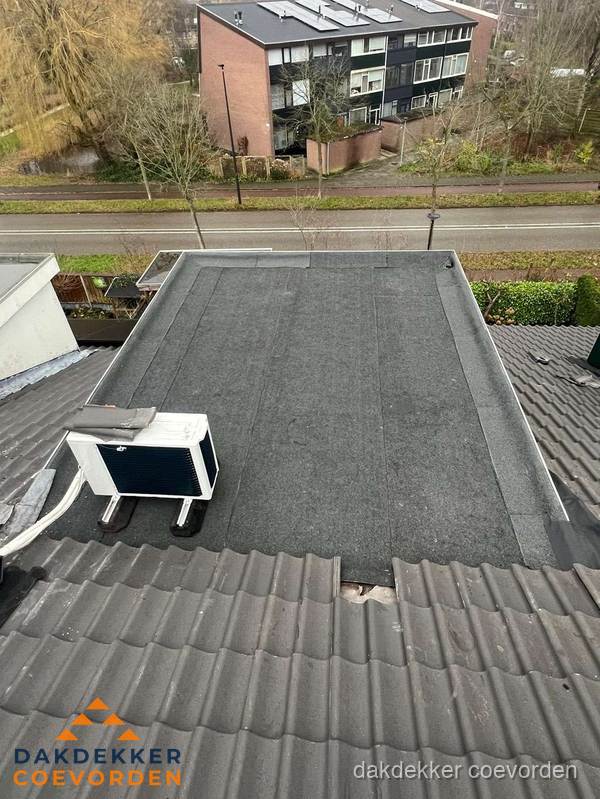 Plat dak inspectie met bitumen bedekking naast schuin pannendak in Coevorden Plat dak inspectie met bitumen bedekking naast schuin pannendak in Coevorden