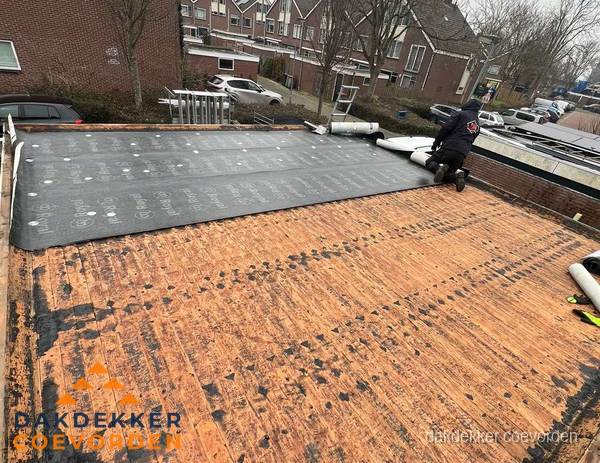 Dakdekker legt onderlaag op plat dak met houten constructie in Coevorden Dakdekker legt onderlaag op plat dak met houten constructie in Coevorden