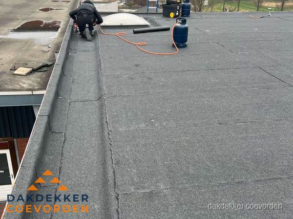 Dakdekker repareert bitumen dakbedekking op groot plat dak in Coevorden Dakdekker repareert bitumen dakbedekking op groot plat dak in Coevorden