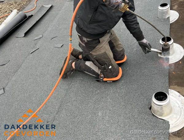 Dakdekker repareert bitumen dakleer bij dakdoorvoer in Coevorden