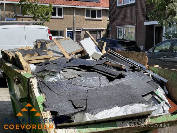 Afvalcontainer met gesloopt dakmateriaal tijdens dakkapel renovatie in Coevorden Afvalcontainer met gesloopt dakmateriaal tijdens dakkapel renovatie in Coevorden