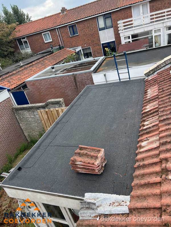 Plat dak aanbouw met bitumen naast schuin pannendak in Coevorden